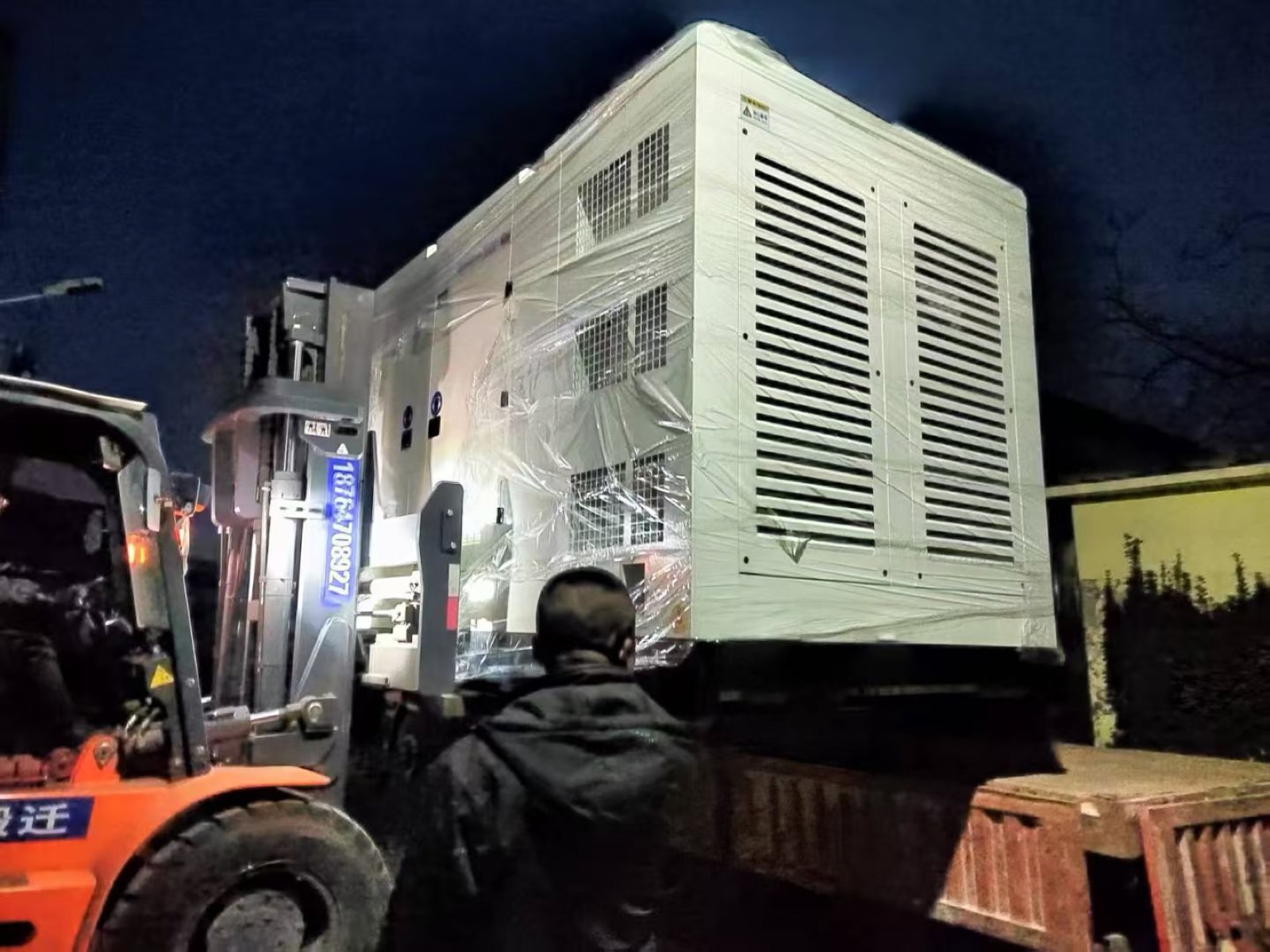 Diesel generator loading by forklift at night